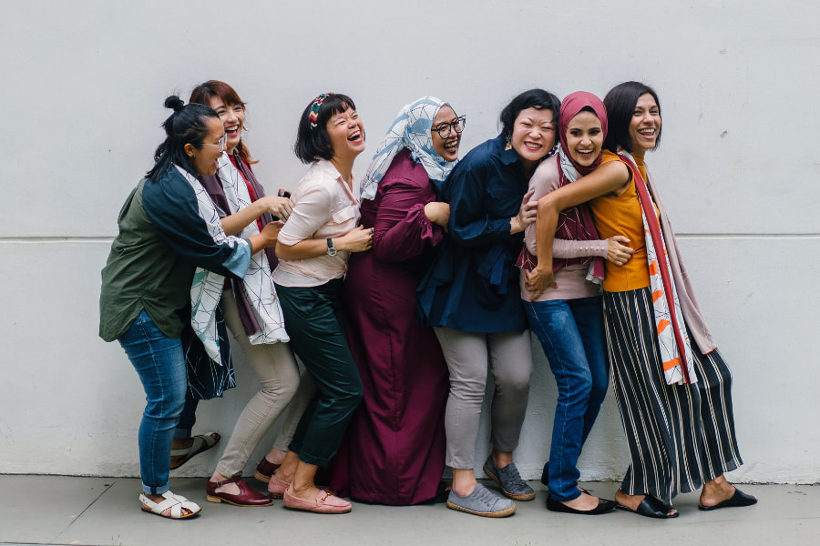 Ryhmä nuoria naisia nauraa yhdessä